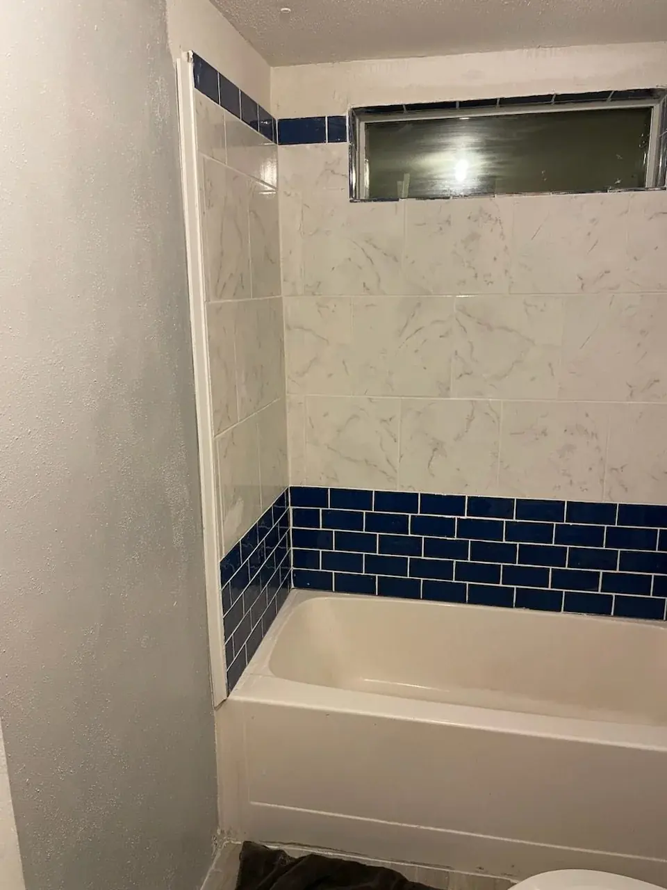 Finished bathroom tub, window, and floor remodel — handyman project photo in Pinellas County FL by Knight Group